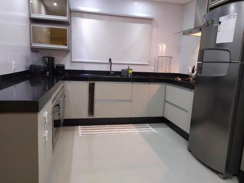 a kitchen with a sink and a refrigerator at Casa Excepcional na Praia Brava - Florianópolis in Florianópolis