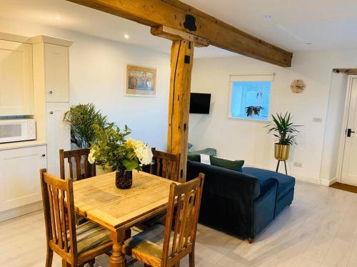 a living room with a table and a couch at The Chaff House Country Cottage in Welsh Newton Common