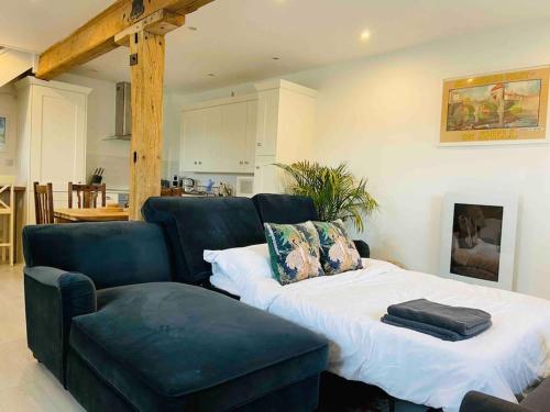 a living room with a bed and a chair at The Chaff House Country Cottage in Welsh Newton Common