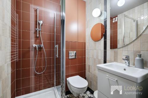 ein Bad mit einer Dusche, einem WC und einem Waschbecken in der Unterkunft Polonia Residence I by LookAp in Łódź