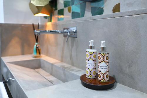 twee flessen odorizers op een aanrecht in een badkamer bij RIAD THE MILESTONE in Marrakesh