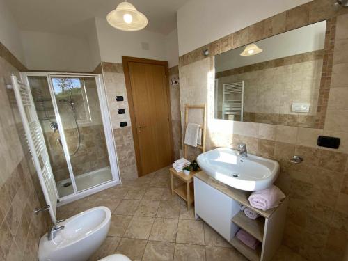 a bathroom with a sink and a toilet and a mirror at La Terrazza Baldo Garda in San Zeno di Montagna