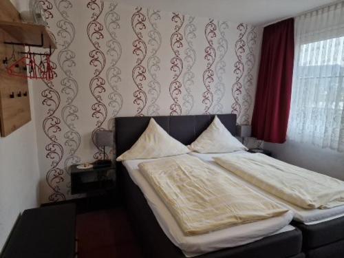 a bedroom with a bed with white sheets and pillows at Hotel Weinhaus Am Stiftstor in Treis-Karden