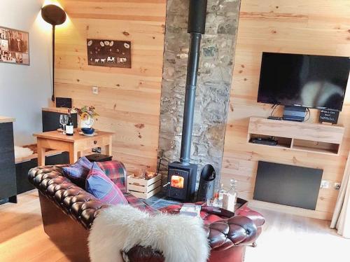 ein Wohnzimmer mit einem Sofa und einem Kamin in der Unterkunft The Bakehouse - by Where Stags Roar in Newtonmore