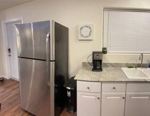 a kitchen with a stainless steel refrigerator and a sink at Brand New 2BR CUTE Blue LED in North Fresno in Fresno