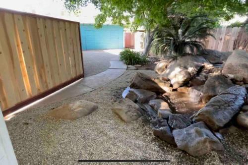 a rock garden with a pond in a yard at Brand New 2BR CUTE Blue LED in North Fresno in Fresno
