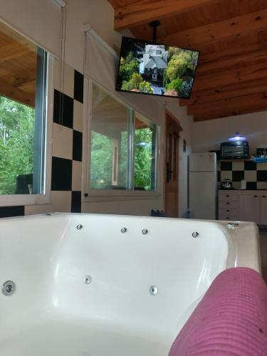 a white bath tub in a room with a tv at Momentos del Espera in Tigre