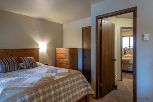 1 dormitorio con cama y espejo en Escape to Ptarmigan Village 59, en Whitefish