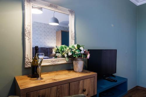 a mirror on top of a dresser with a vase of flowers at Avenue Hotel - Free Parking in Sofia