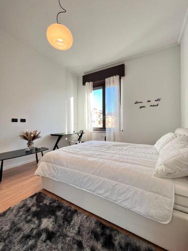 a white bedroom with a large bed and a window at Kibilù - Via Taormina - Ospedale Niguarda - Isola in Milan