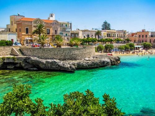 サンタ・マリア・アル・バーニョにあるAppartamento Girasoleのターコイズブルーの水と建物が備わるビーチの景色を望めます。