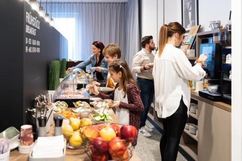 eine Gruppe von Menschen, die um ein Buffet stehen in der Unterkunft Motel Schlafraum Schlüßlberg-Dein smartes Hotel-contactless check-in in Schlüßlberg