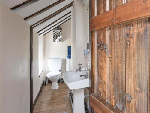 y baño con aseo blanco y lavamanos. en Oxlow End Cottage, en Peak Forest