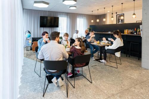 a group of people sitting at tables in a restaurant at Motel Schlafraum Schlüßlberg-Dein smartes Hotel-contactless check-in in Schlüßlberg