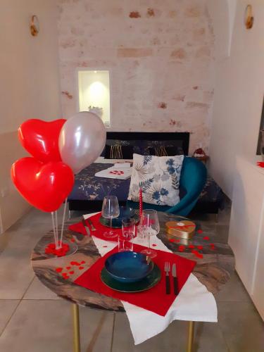 una mesa con globos rojos y blancos y una mesa con mesa de mesa en Mosa Home, en Ostuni