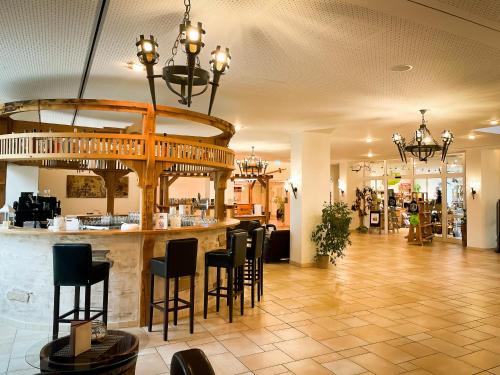 ein Restaurant mit einer Bar und Stühlen in der Lobby in der Unterkunft Hasseröder Burghotel in Wernigerode