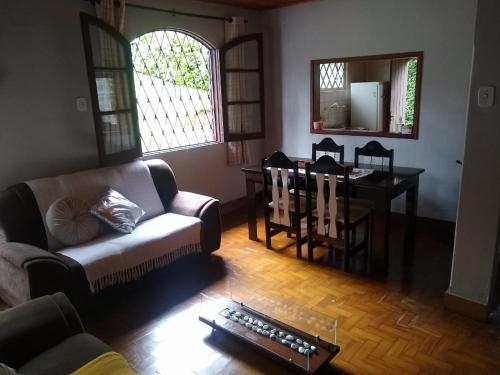 a living room with a couch and a table at Recanto Dorinha in Campos do Jordão