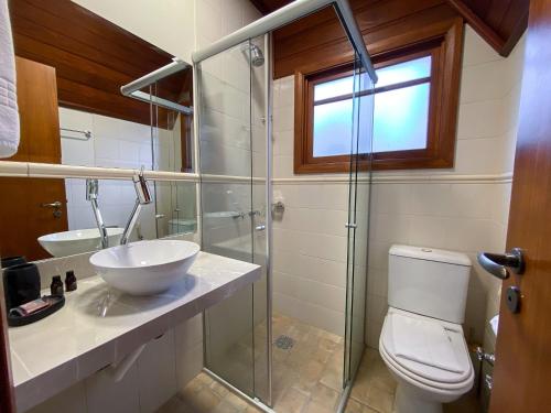 y baño con lavabo, aseo y ducha acristalada. en LOCAR-IN GRAMADO - Orquideas 150 m da Rua Coberta, en Gramado