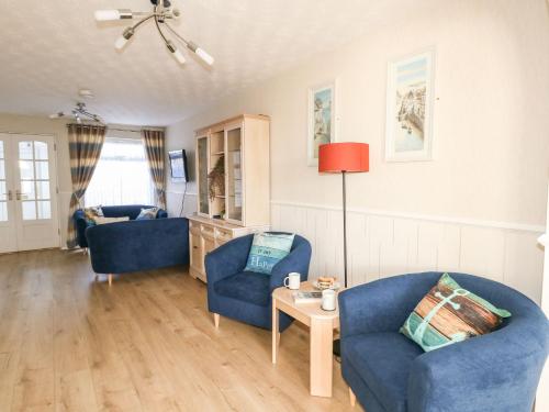 een woonkamer met twee blauwe stoelen en een tafel bij Milton House in Weymouth