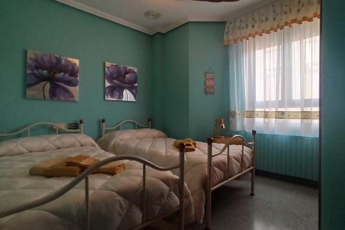 duas camas num quarto com paredes verdes em Yayo-Toni de Banyeres em Banyeres de Mariola
