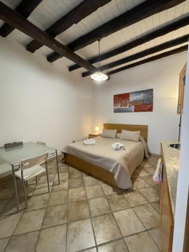 ein Schlafzimmer mit einem Bett und einem Tisch darin in der Unterkunft Baglio Judica Apartments in Palermo