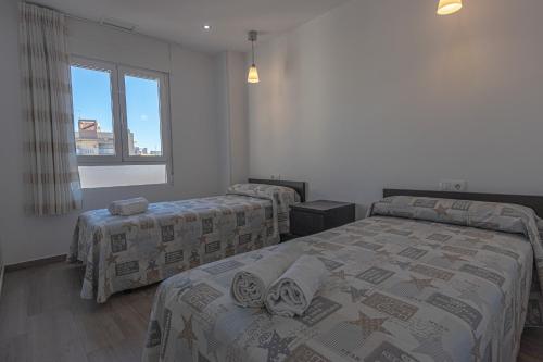 1 dormitorio con 2 camas y ventana en 074 - Gaviotas 003 - comfortHOLIDAYS, en Santa Pola