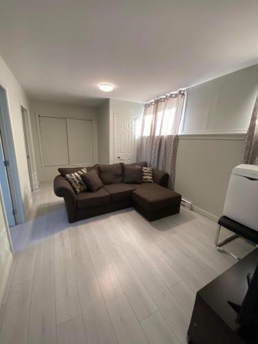 a living room with a couch and a chair at Le Cardinal in Rouyn