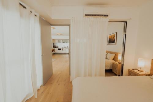 sypialnia z białymi zasłonami i łóżkiem w pokoju w obiekcie Beaufort Street Gem 1br Urban Retreat w mieście Perth