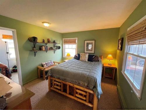 a bedroom with a bed in a room with green walls at Close to skiing and hiking, walk to main street in Tannersville