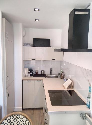 une petite cuisine avec des armoires blanches et un évier dans l'établissement Résidence Graziella Studio 508, à Juan-les-Pins