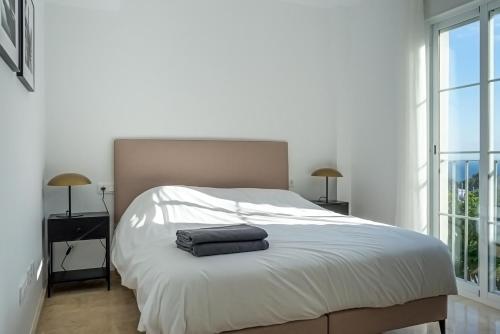マニルバにあるApartment Manilvaのベッドルーム(白い大型ベッド、ランプ2つ付)