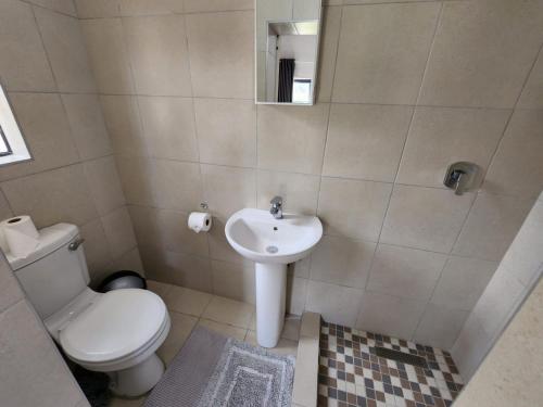 La salle de bains est pourvue de toilettes et d'un lavabo. dans l'établissement 9 Levubu Cottages, à Polokwane