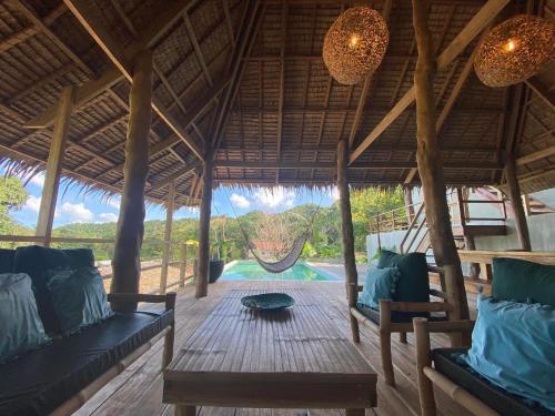 a pavilion with a table and chairs and a pool at Sampaguita Villas in El Nido