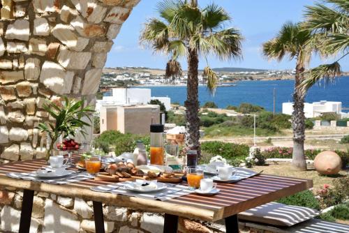 drewniany stół z jedzeniem i widokiem na ocean w obiekcie Executive Paros Villa Villa Avra Sea View and Outdoor Jacuzzi Villa Kostos Damouli w mieście Paros