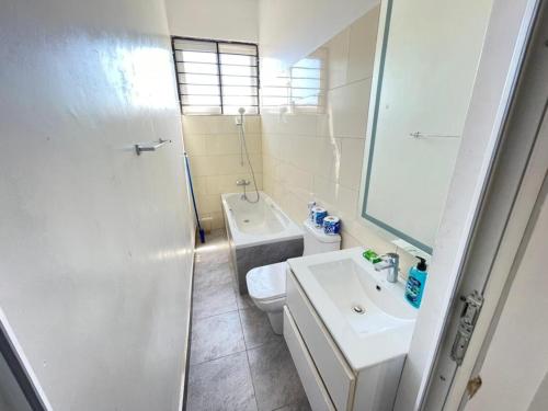 uma casa de banho branca com um lavatório e um WC em Travellers stay em Dar es Salaam