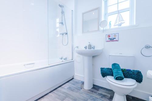 Baño blanco con aseo y lavamanos en Modern 4-Bed Townhouse in Crewe by 53 Degrees Property, Ideal for Contractors & Business, FREE Parking - Sleeps 8, en Crewe