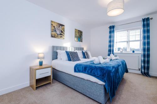 um quarto com uma cama grande e um cobertor azul em Modern 4-Bed Townhouse in Crewe by 53 Degrees Property, Ideal for Contractors & Business, FREE Parking - Sleeps 8 em Crewe