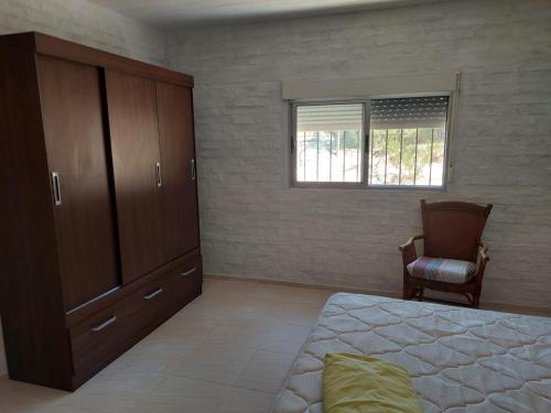 1 dormitorio con 1 cama, vestidor y silla en Hermosa Casa en Jaureguiberry, en Jaureguiberry