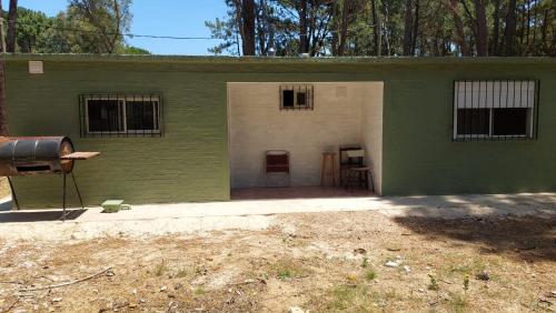 a green and white building with a door and a grill at Hermosa Casa en Jaureguiberry in Jaureguiberry