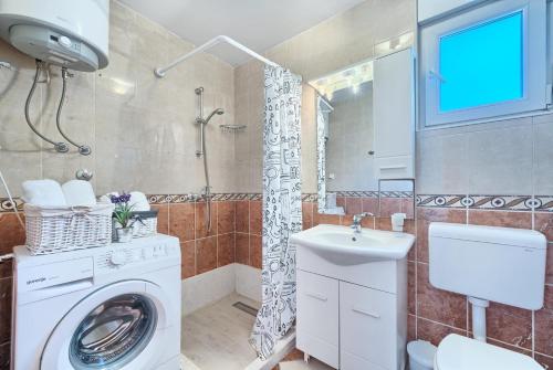 La salle de bains est pourvue d'un lave-linge et d'un lavabo. dans l'établissement Apartment in Kastel Luksic with balcony, air conditioning, W-LAN, washing machine 5107-4, à Kaštela