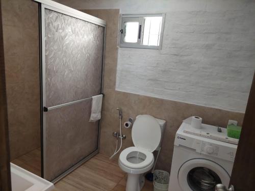 a bathroom with a toilet and a washing machine at Hermosa Casa en Jaureguiberry in Jaureguiberry