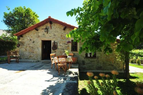 a small stone house with a table and chairs at Casas de Santiago in Vila Nova de Cerveira