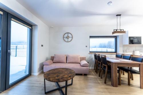 a living room with a table and a couch at Domki Słoneczna 11 z widokiem na Śnieżkę in Karpacz