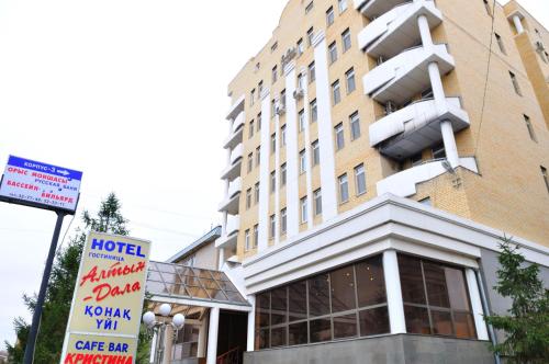 a hotel building with a sign in front of it at Altyn Dala Hotel in Astana