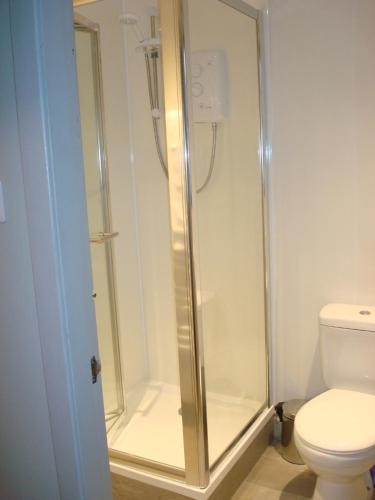 a shower stall in a bathroom with a toilet at Dunvegan Castle Laundry Cottage in Dunvegan