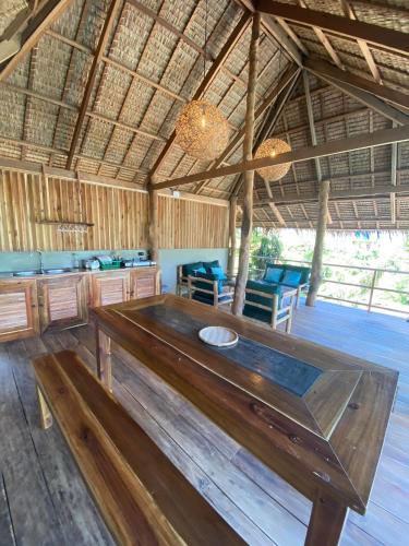 a large wooden table in a room with blue chairs at Sampaguita Villas in El Nido