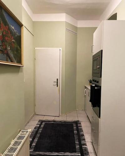 een keuken met een witte deur en een zwart tapijt bij Gemütliche Wohnung in Wien in Wenen
