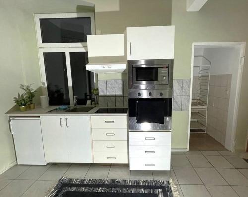 een keuken met witte kasten en een magnetron bij Gemütliche Wohnung in Wien in Wenen