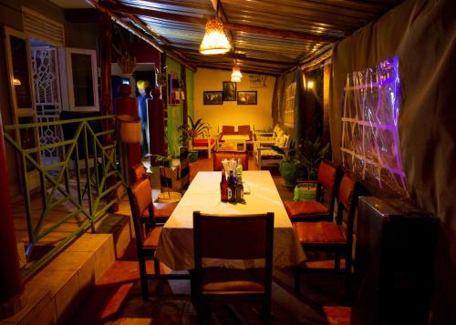 Richy Hotels and Safaris في Mbale: غرفة طعام مع طاولة وكراسي طويلة
