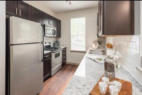 uma cozinha com armários pretos e um frigorífico branco em Comfy Casa Entertainment em Charlotte